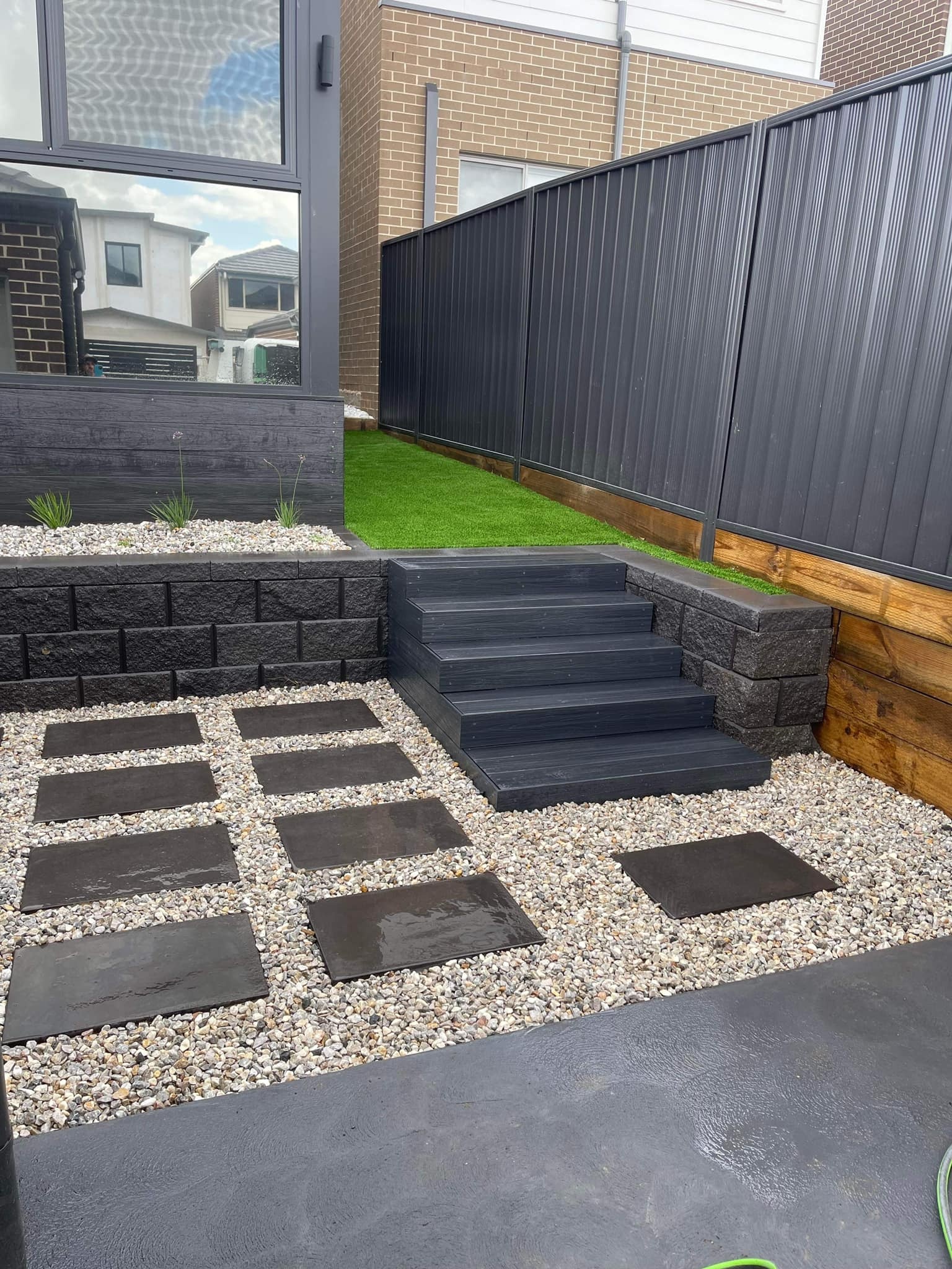 Transformed backyard with steps, pavers and pebbles