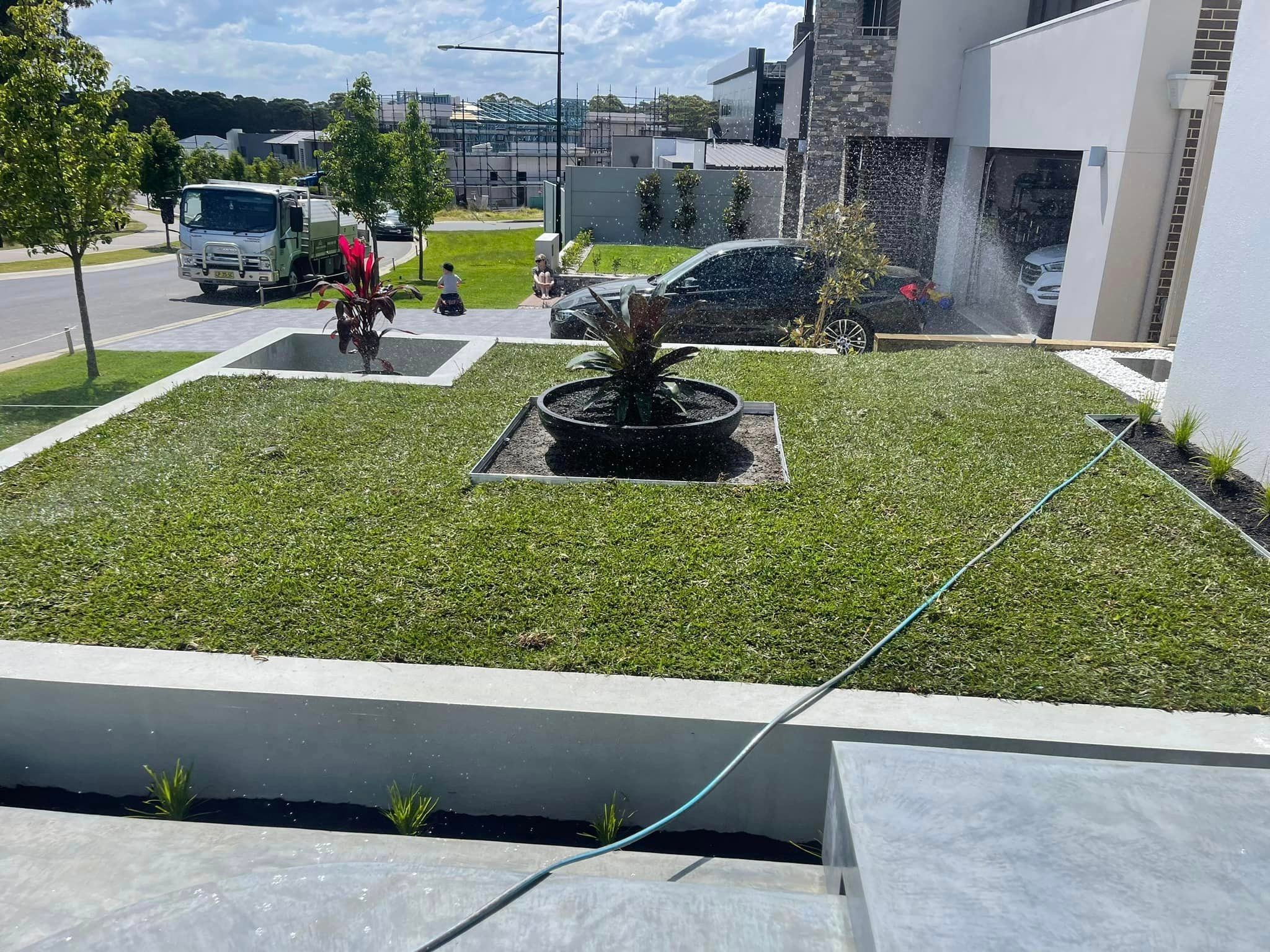 Concrete front steps and retaining wall with raised garden area