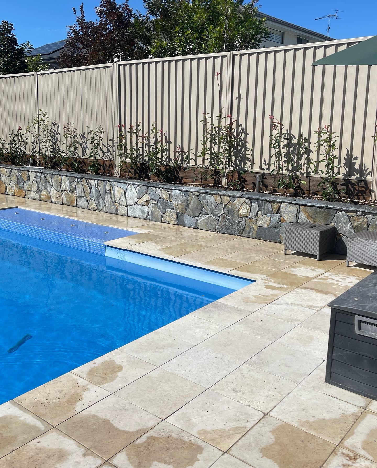 Pool surrounds with stone retaining wall