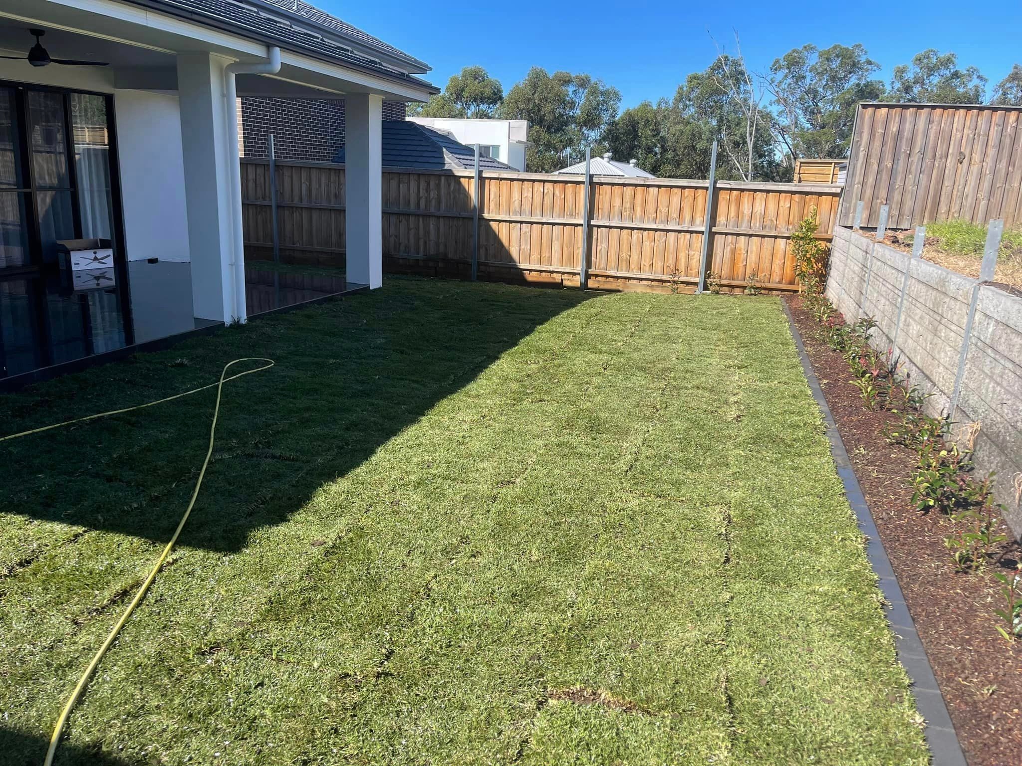 Wooden fencing and newly turfed lawn