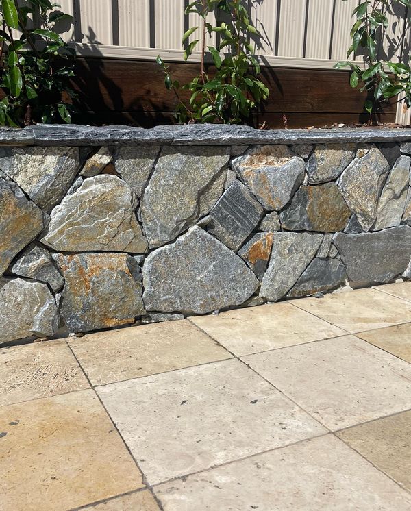 Stone retaining walls and paved pool surrounds