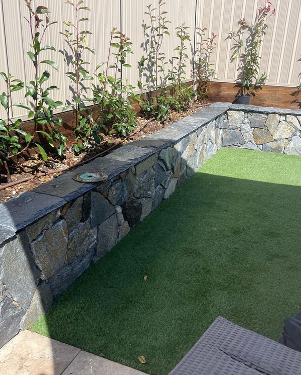 Water dripper irrigation system in raised retaining wall garden bed