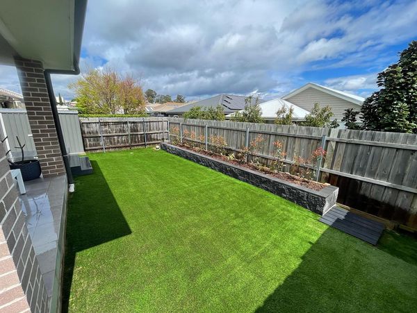 Backyard with grass turfing and raised garden